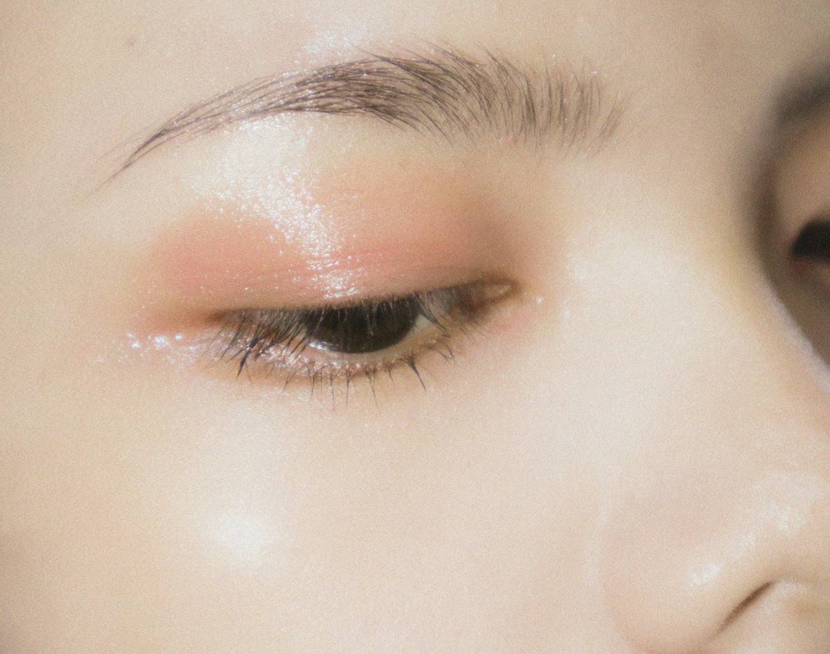 Professional applying brow tint with a precision brow tinting aid